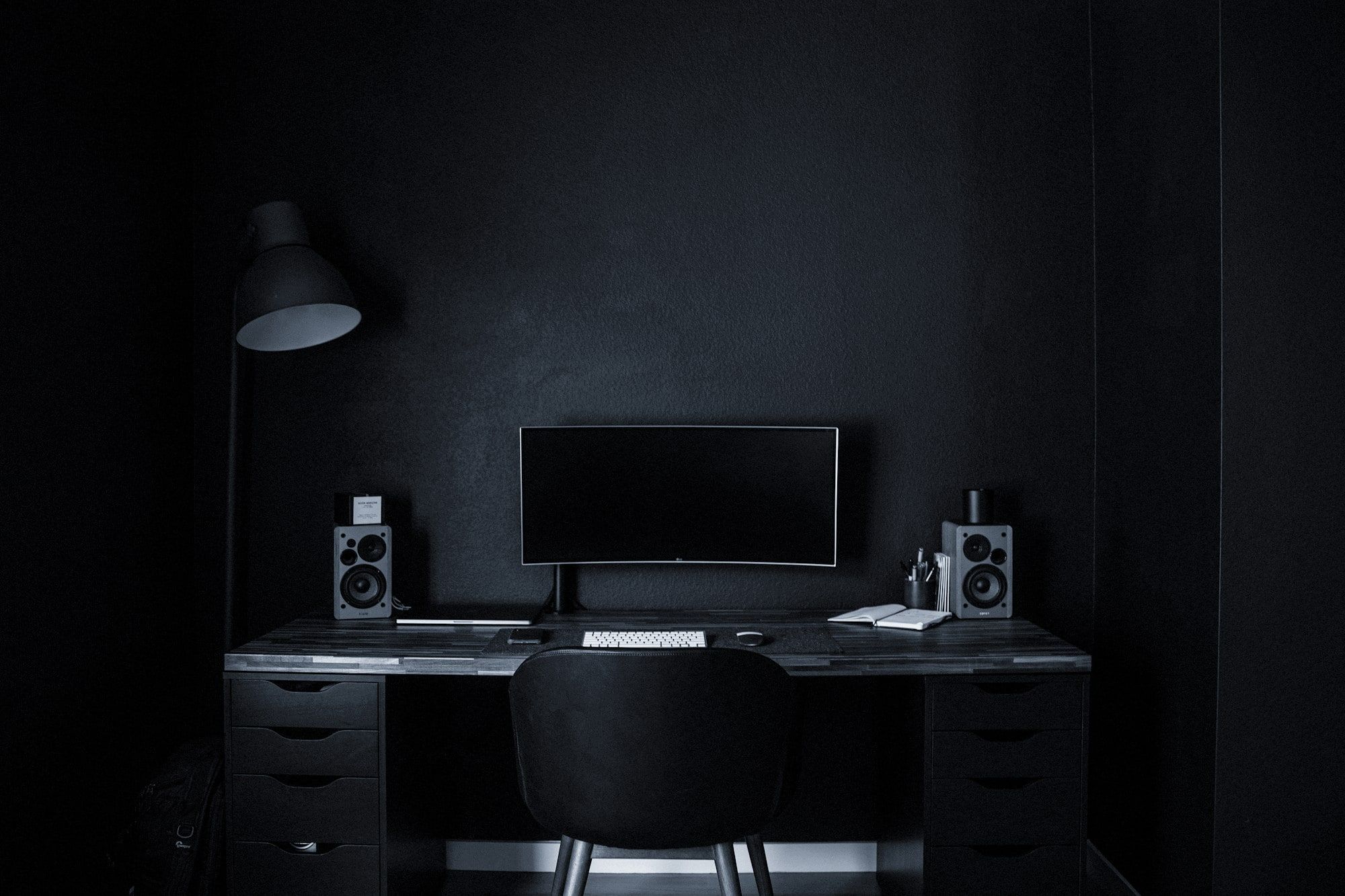 A minimal workstation with a single monitor in a dark room